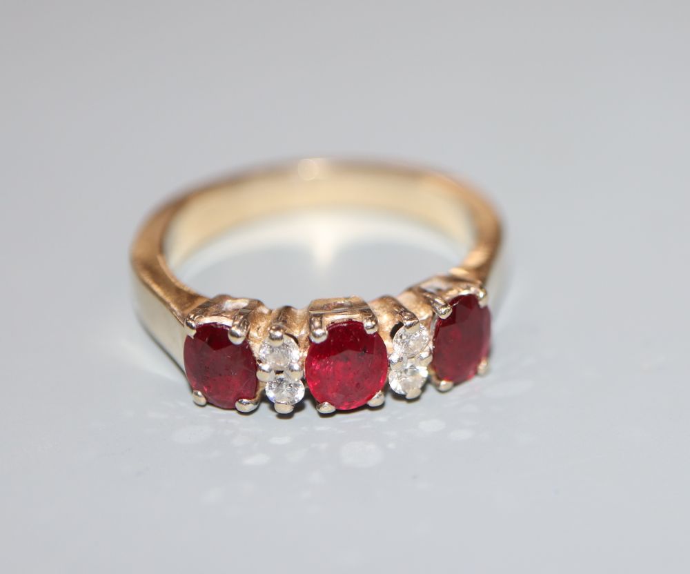 A modern 18ct, ruby and diamond set dress ring, size M, gross 5.6 grams.